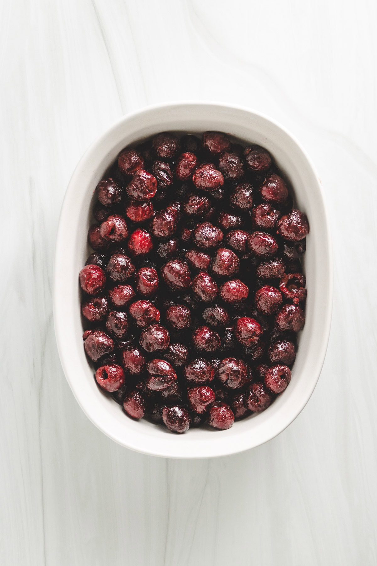 Fresh cherry filling in a white dish.