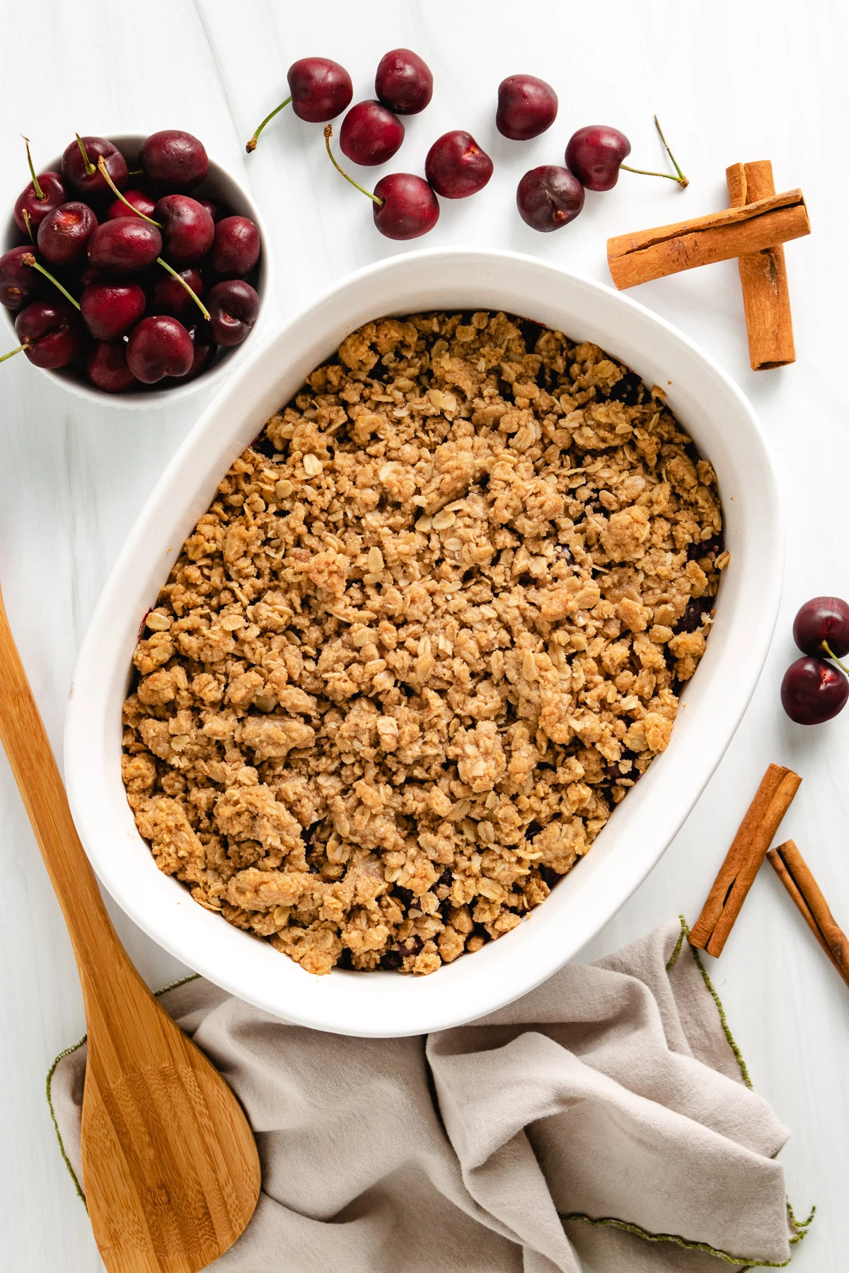 Baked fruit crisp in a white baking dish.