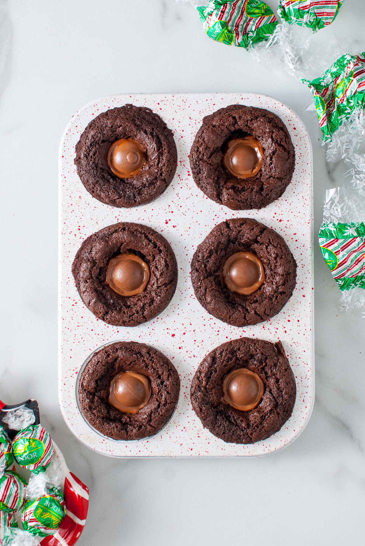 Chocolate truffles melting in the centers of baked brownies.