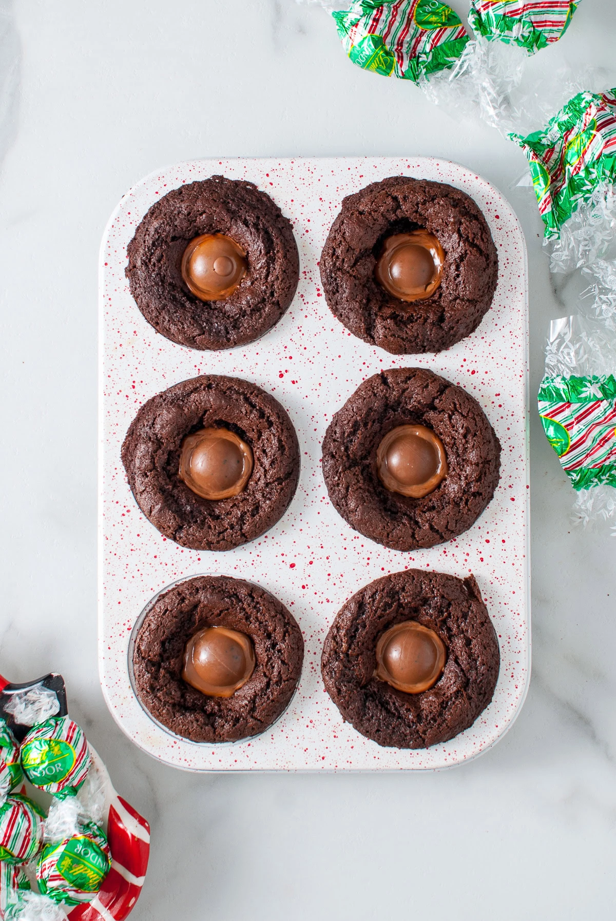Chocolate truffles melting in the centers of baked brownies.