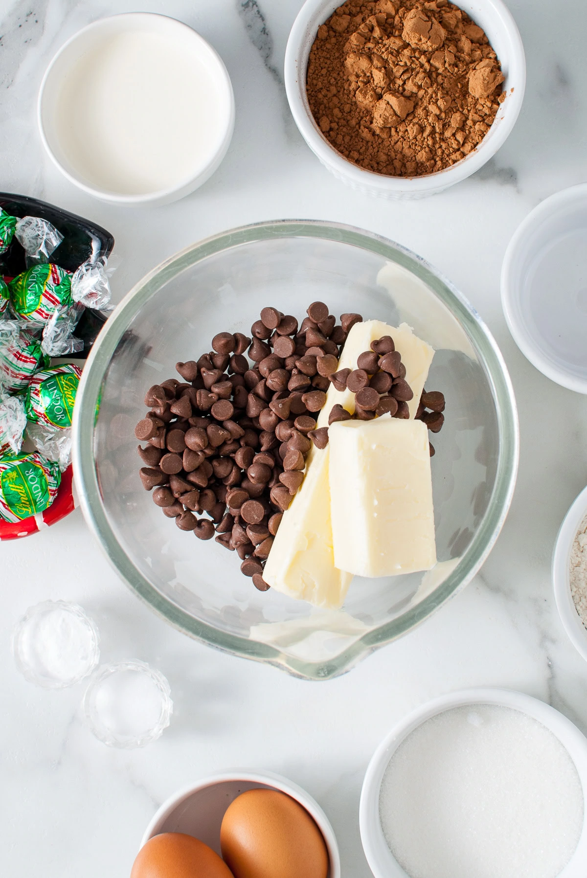 Butter and chocolate chips in a glass mixing bowl.
