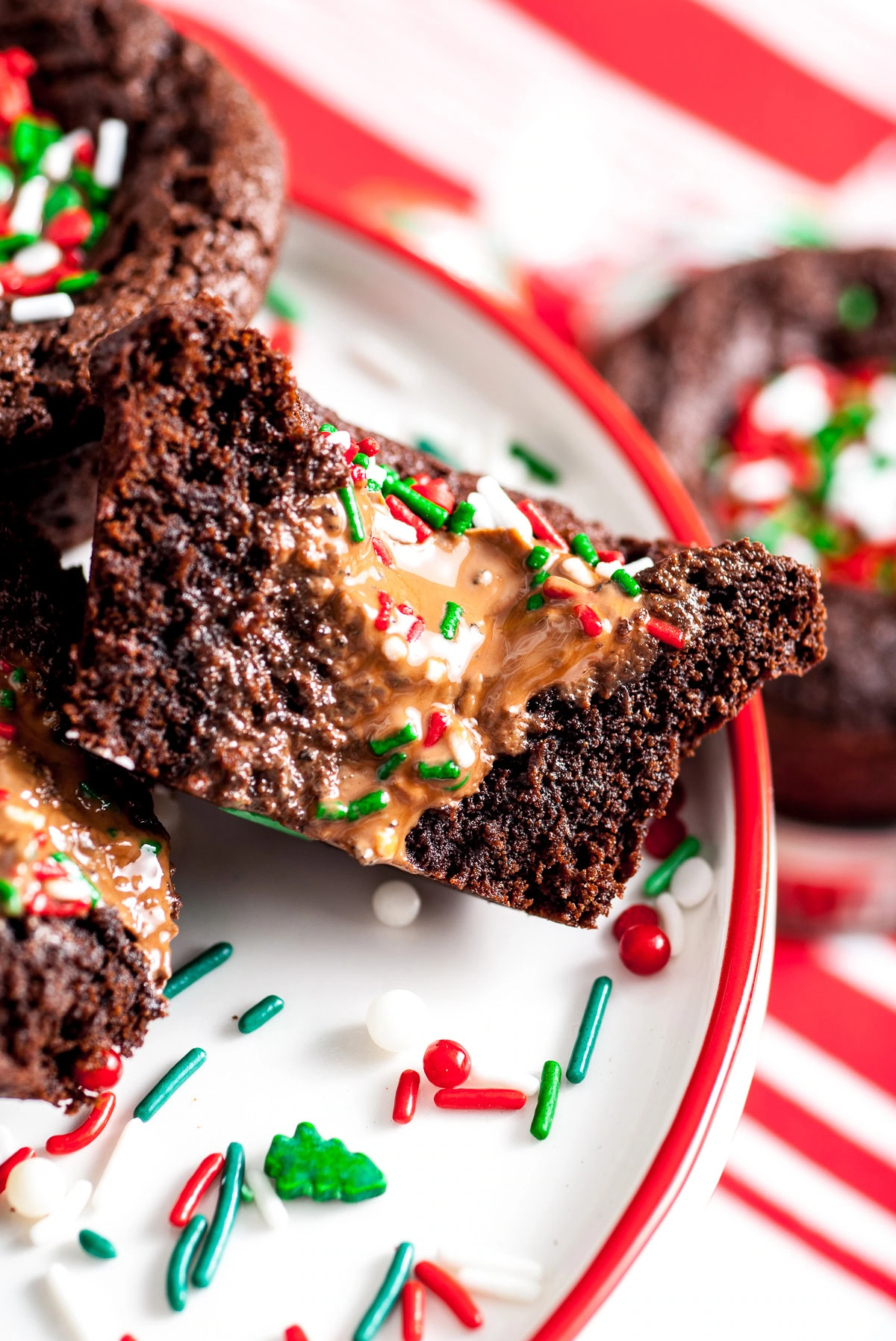 Christmas brownies arranged on a serving plate with scattered sprinkles and truffles.