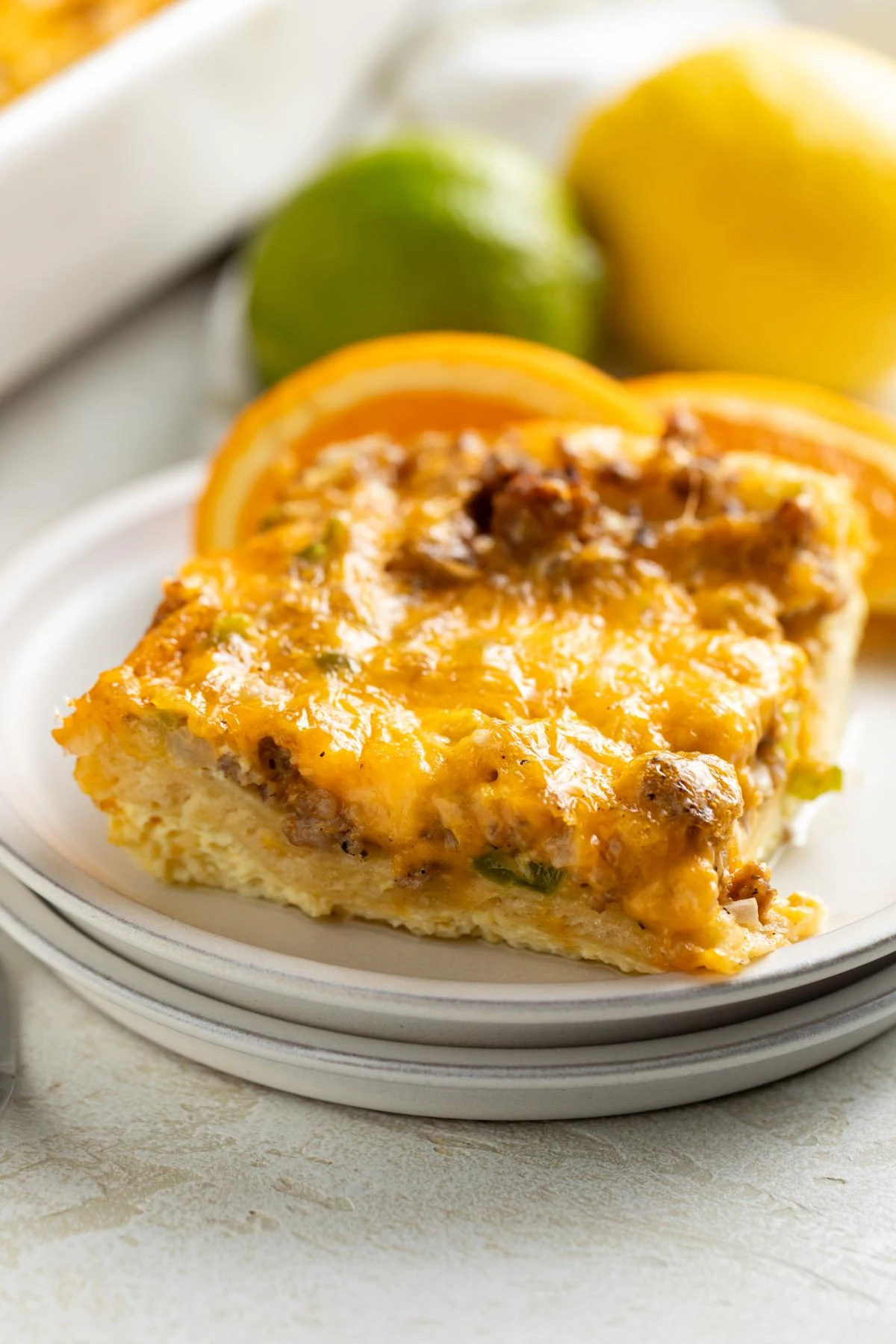 The sliced breakfast casserole shows layers of eggs, sausage, and crescent dough.