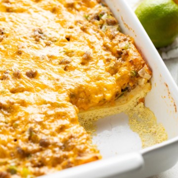 Crescent roll breakfast casserole with sausage is shown in a white baking dish.
