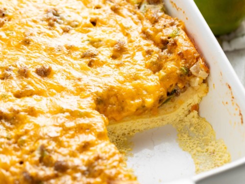 Crescent roll breakfast casserole with sausage is shown in a white baking dish.