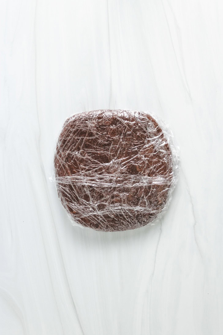 Chocolate cookie dough wrapped in plastic wrap.