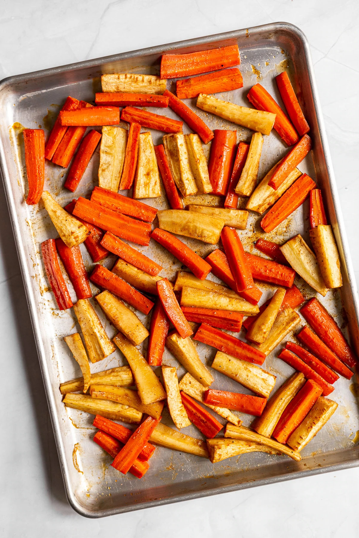 Roasted carrots and parsnips topped with walnuts and parsley.