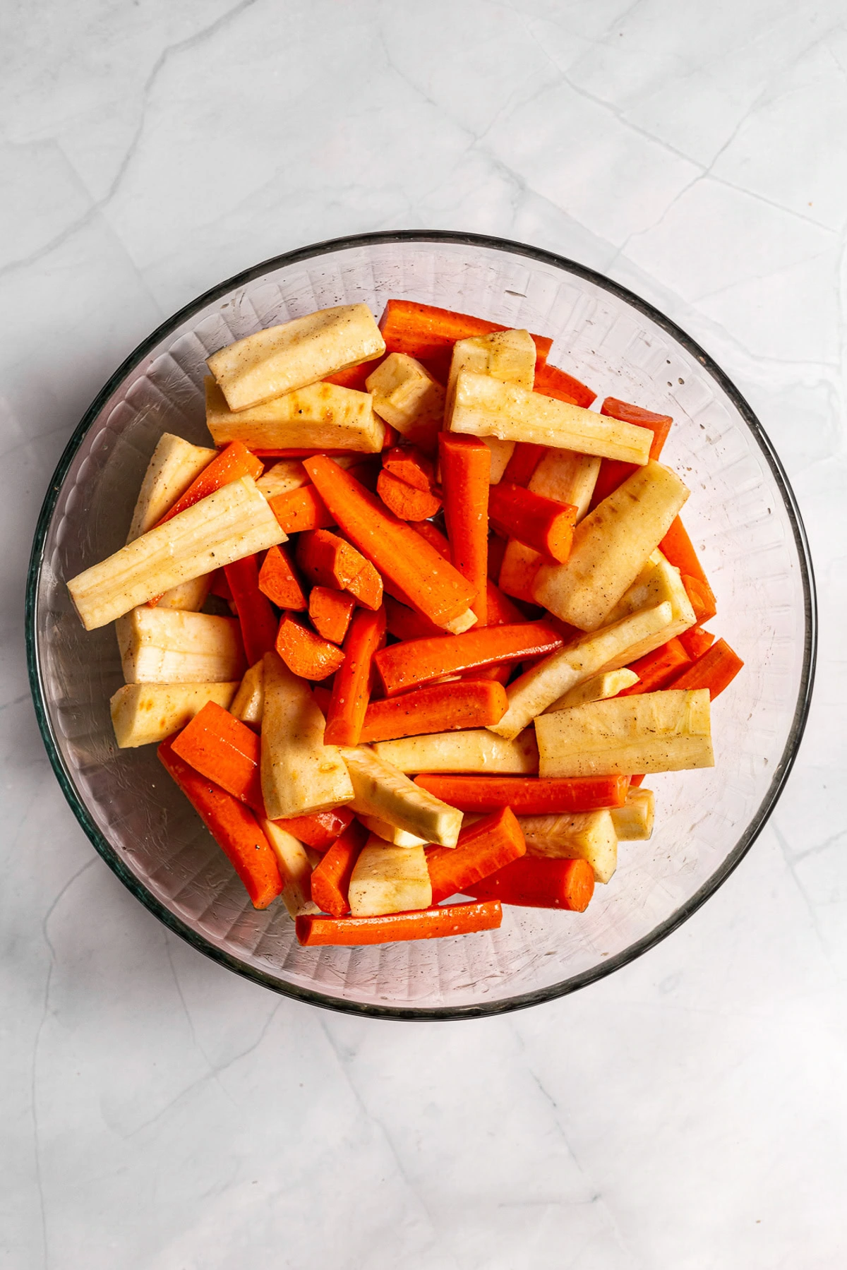 Carrots and parsnips spread on a sheet pan.