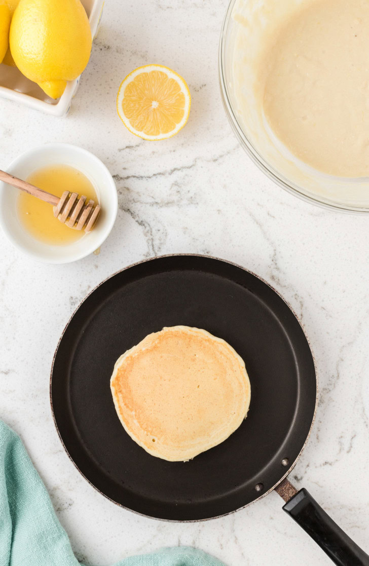 Cooked lemon ricotta pancake in a black skillet.
