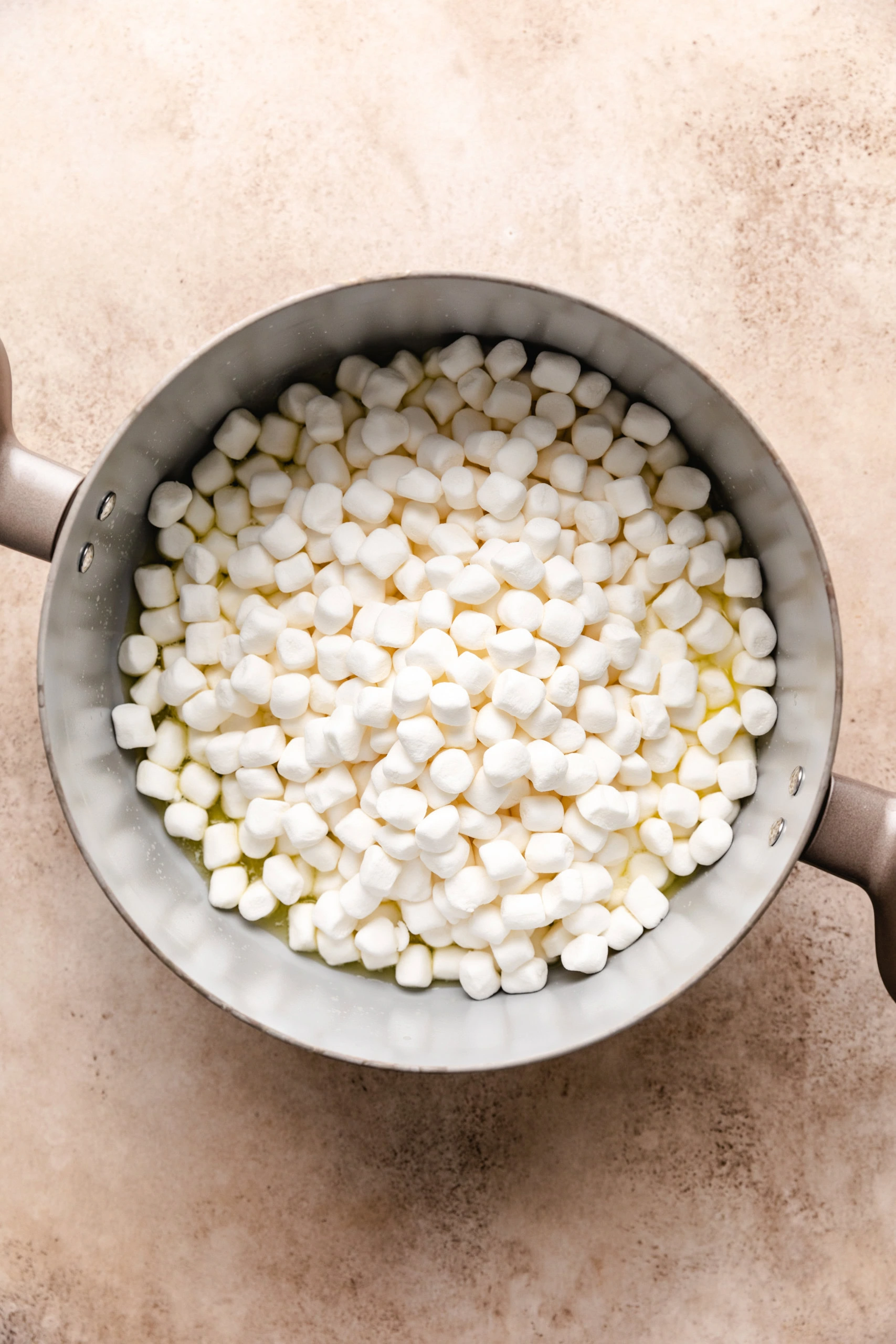Mini marshmallows added to melted butter in a saucepan.