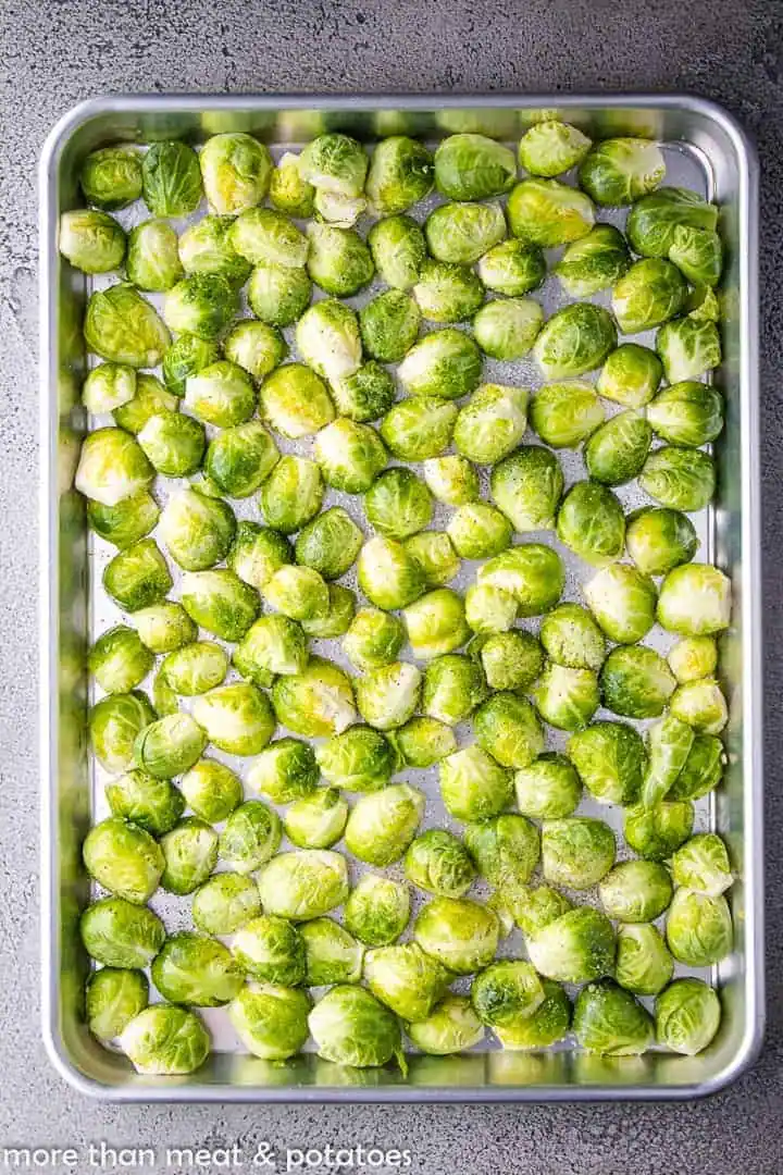 Brussels sprouts spread on a baking sheet.