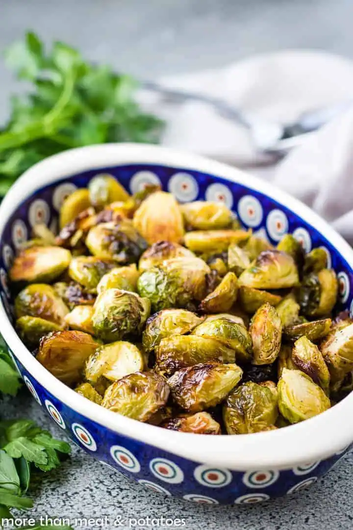 Roasted Brussels sprouts served in a blue patterned bowl.