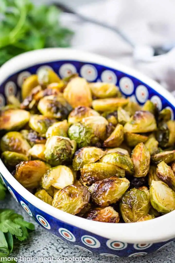Close-up of roasted Brussels sprouts in a serving dish.