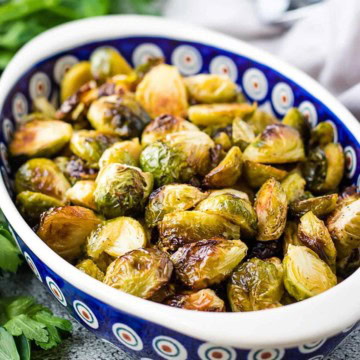 Close-up of roasted Brussels sprouts in a serving bowl.