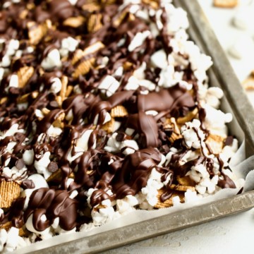 S'mores popcorn mix with marshmallows, cereal, chocolate chips, and melted chocolate.