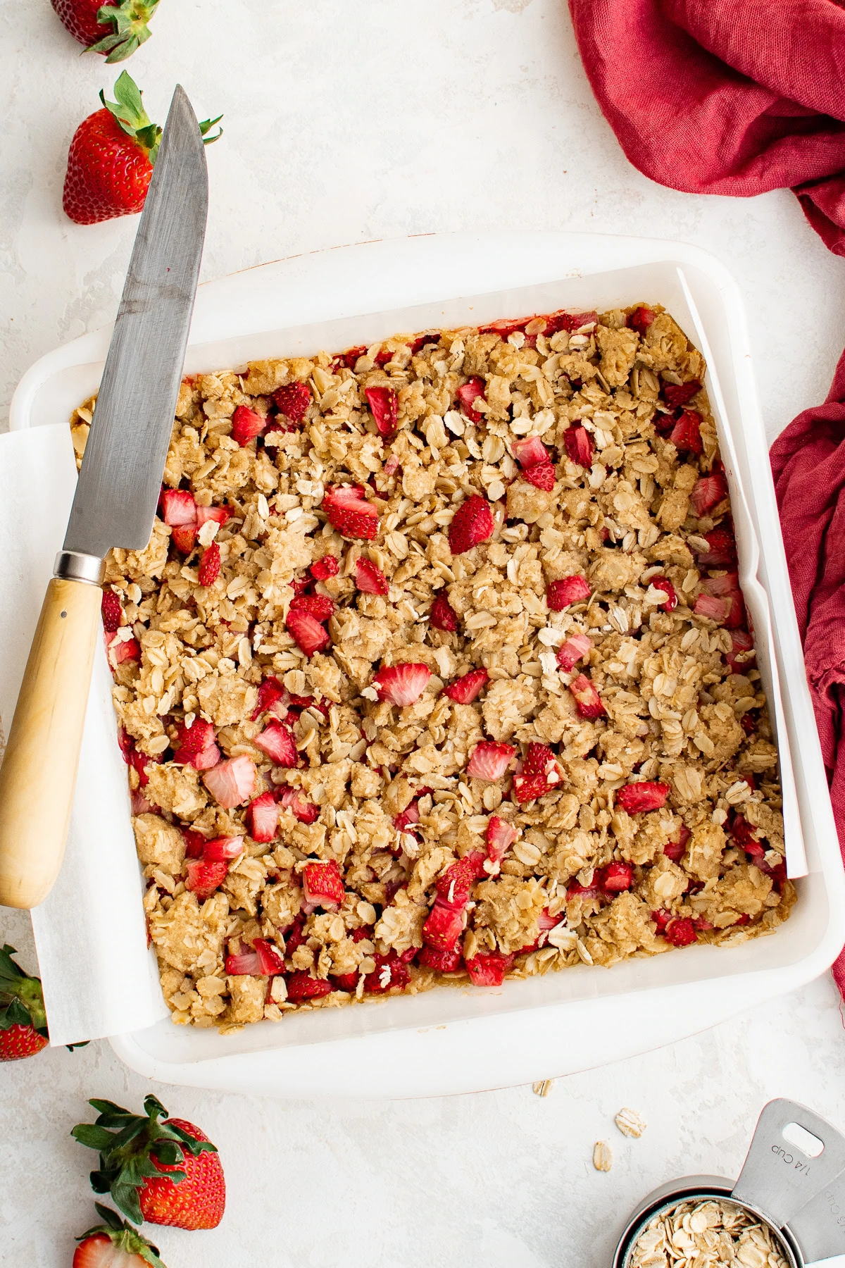 Strawberry oatmeal bars with a knife in the baking dish.