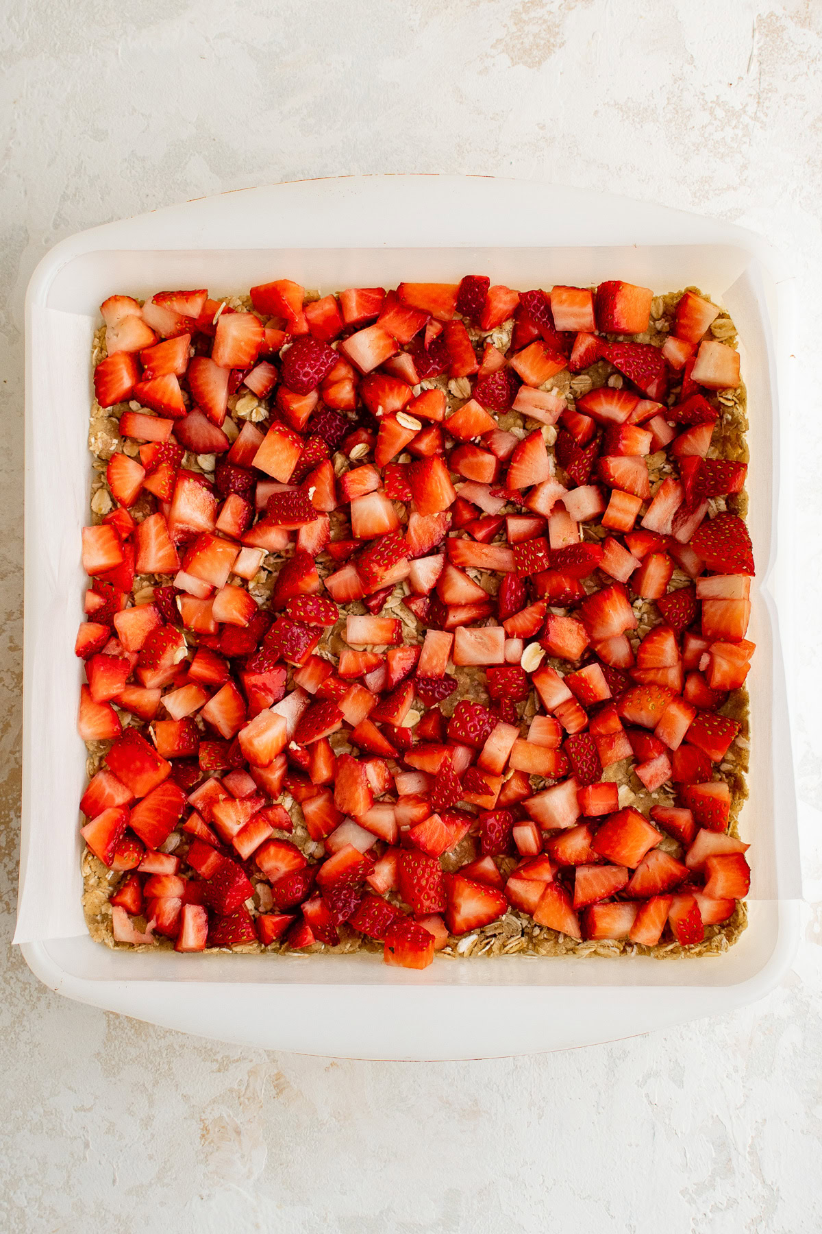 Chopped strawberries spread over oatmeal crust.