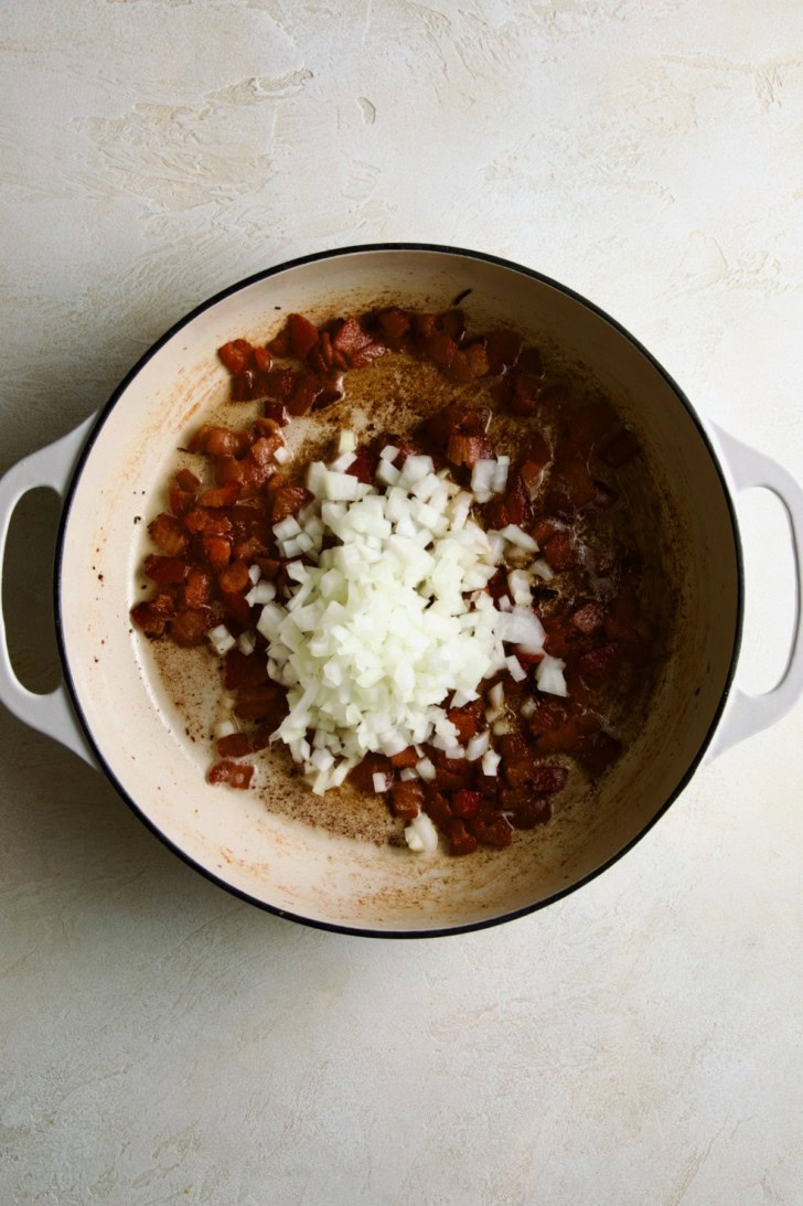 Cooked bacon with diced onion added to the pot.