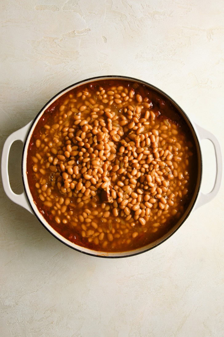 Canned beans added to the seasoned bacon mixture.