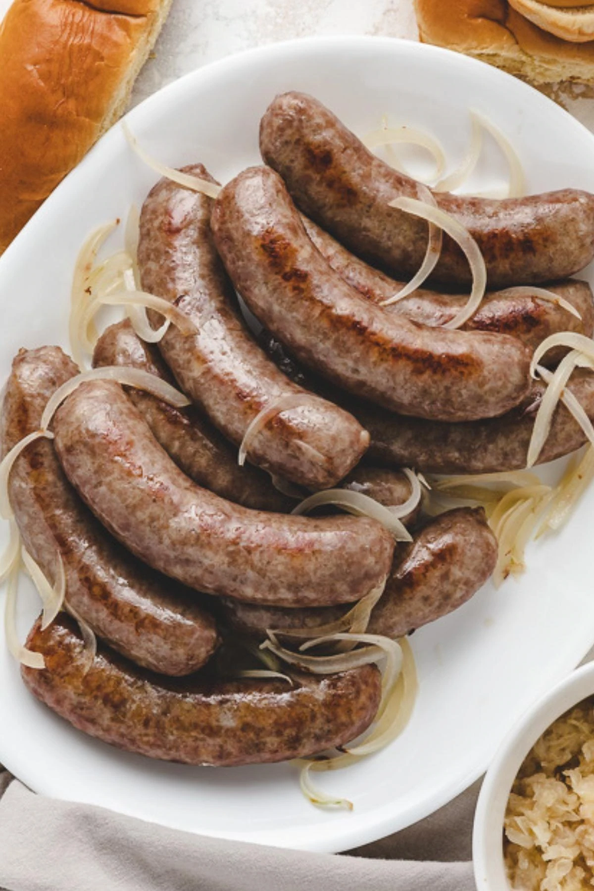 Overhead view of baked brats on a plate.