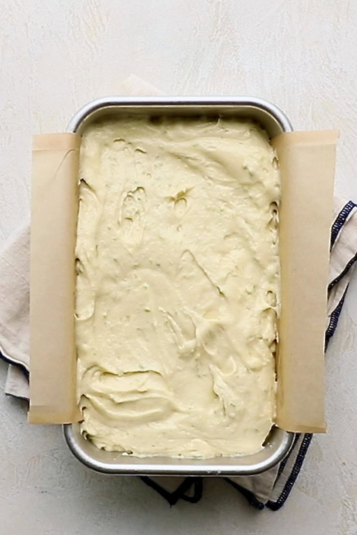 Key lime pound cake batter spread in a loaf pan.