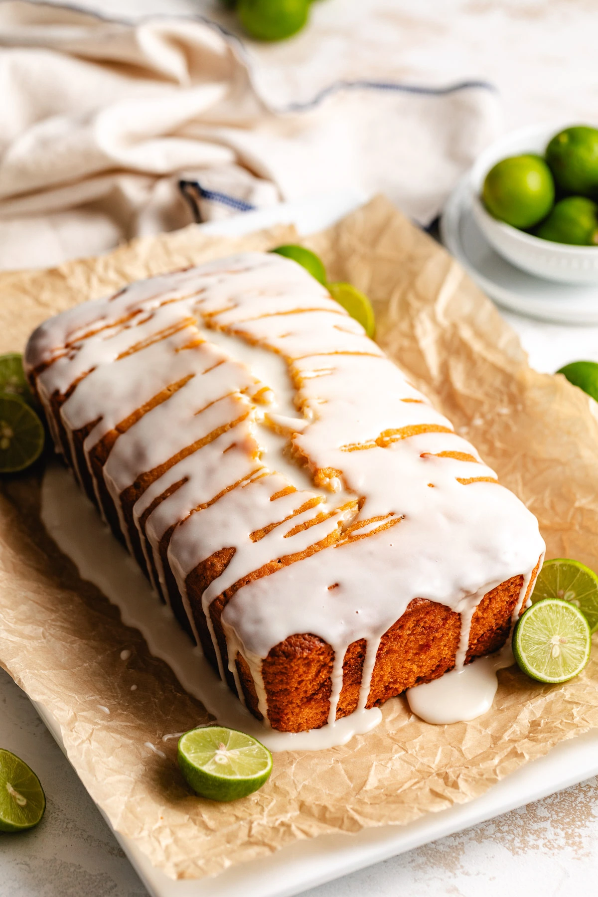 Key lime pound cake topped with glaze and served with limes.