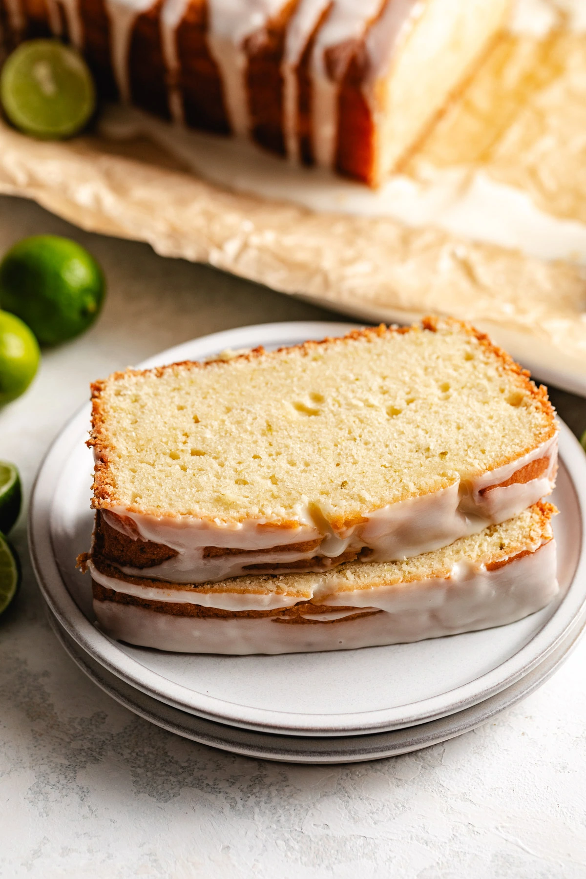 Two slices of glazed key lime pound cake on a plate.