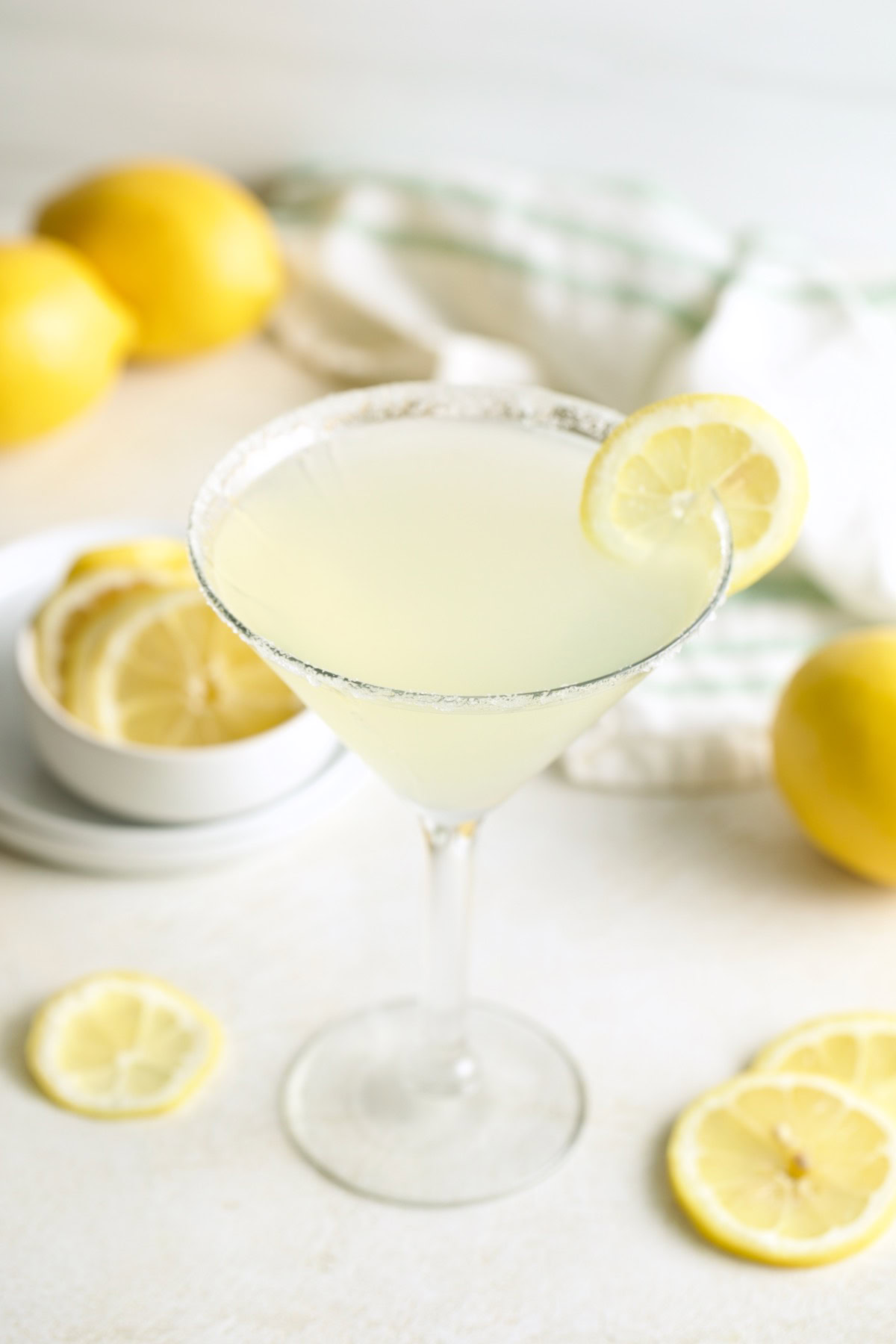 Lemon drop cocktail served with fresh lemons and lemon slices.