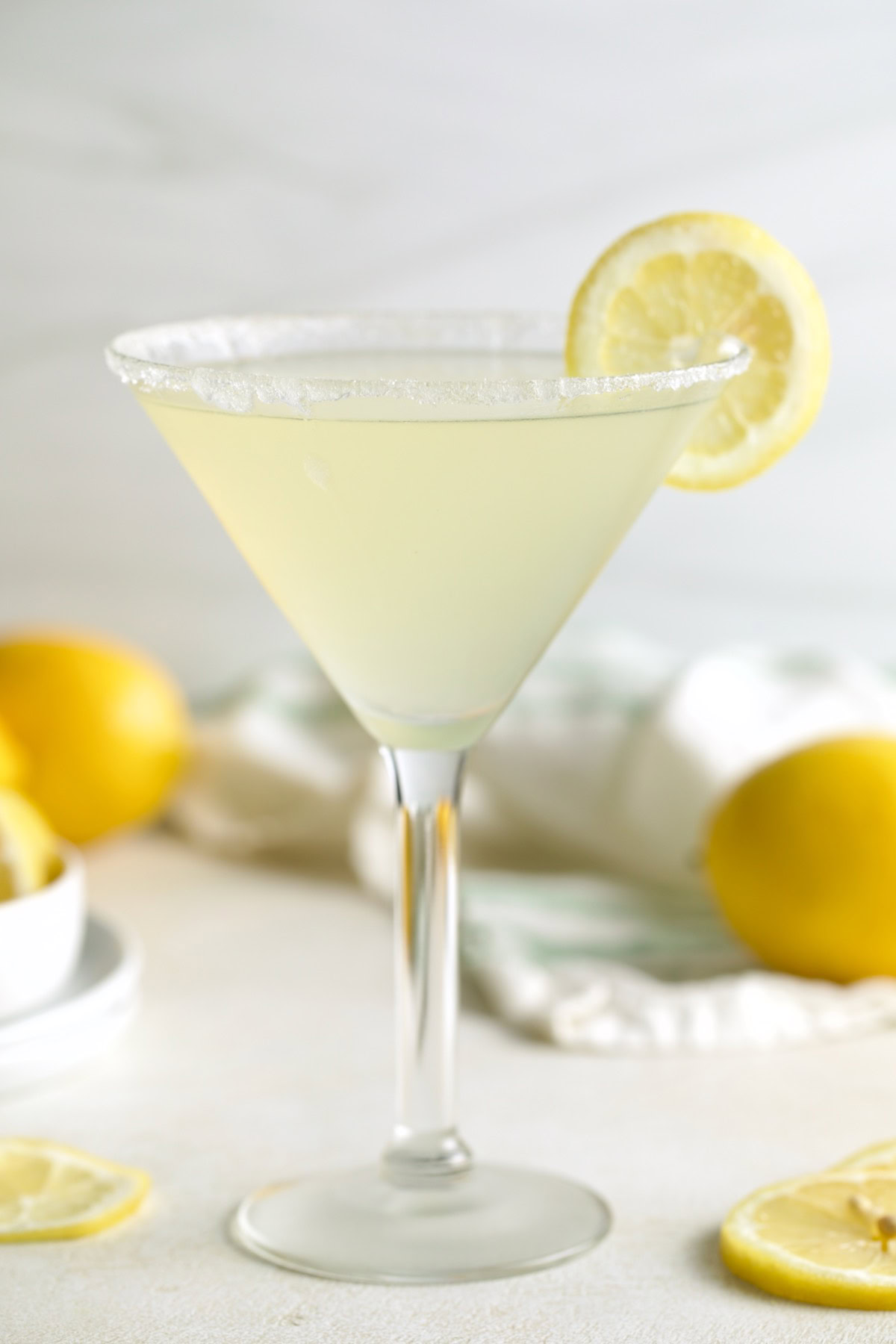 Pale yellow lemon drop cocktail served in a sugar-rimmed martini glass.