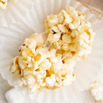 Overhead view of a gooey popcorn ball on a paper liner.