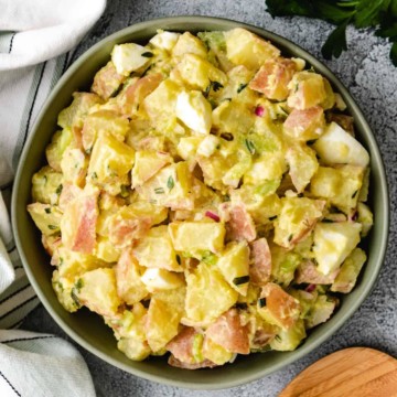 Potato salad with mustard vinaigrette served in a green bowl.