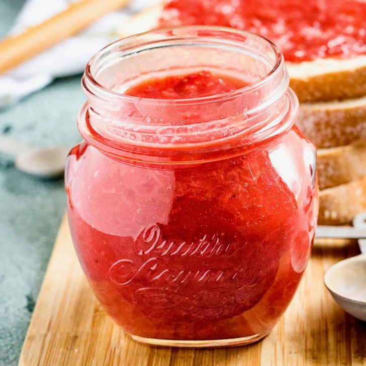 Close-up of strawberry jam in a glass jar.