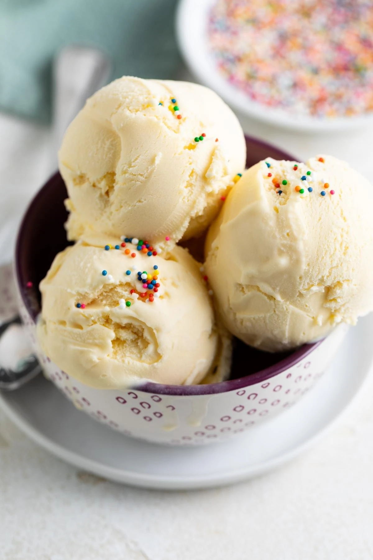 Close-up of vanilla ice cream scoops with colorful sprinkles.