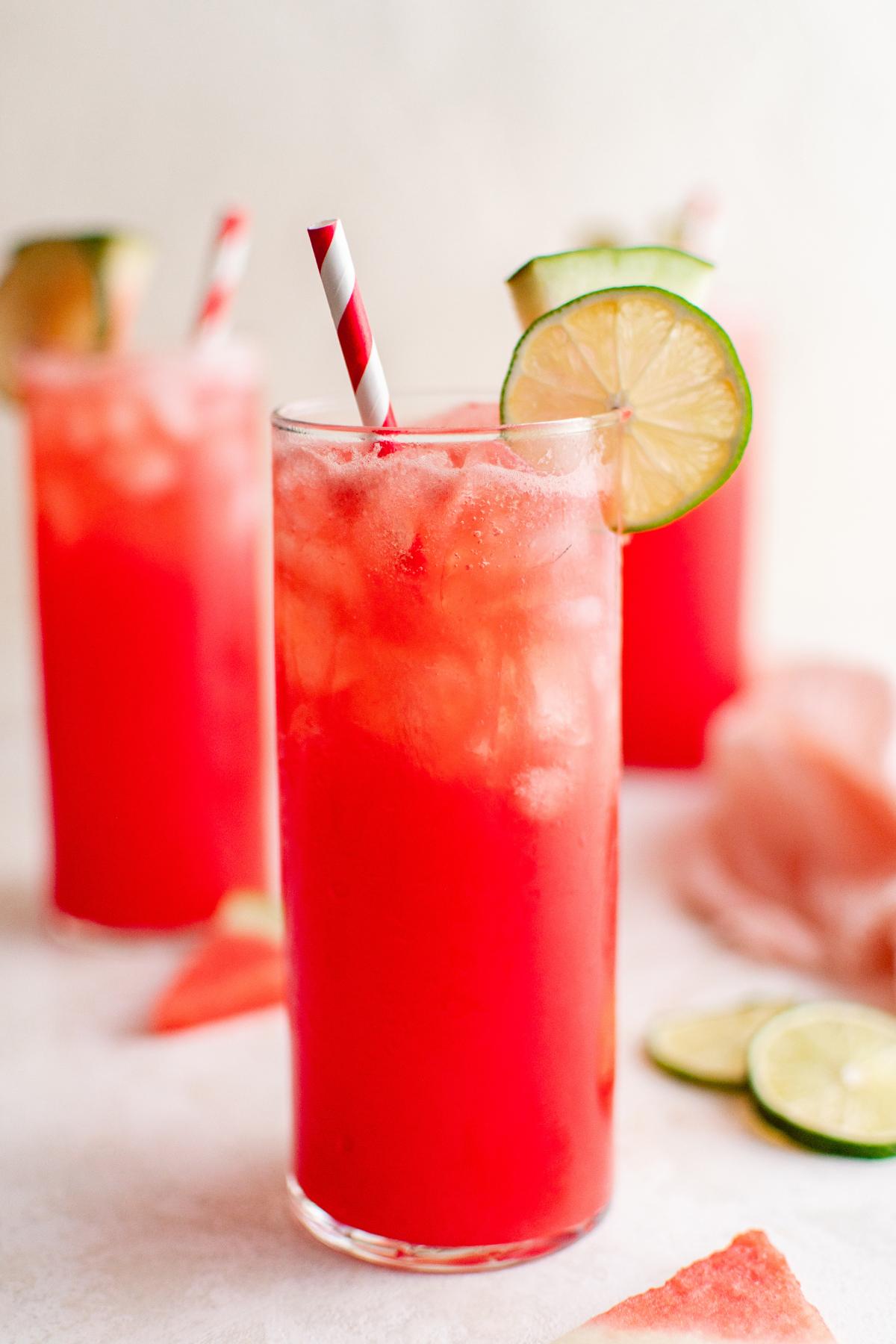 Watermelon agua fresca with a straw and lime wheel.