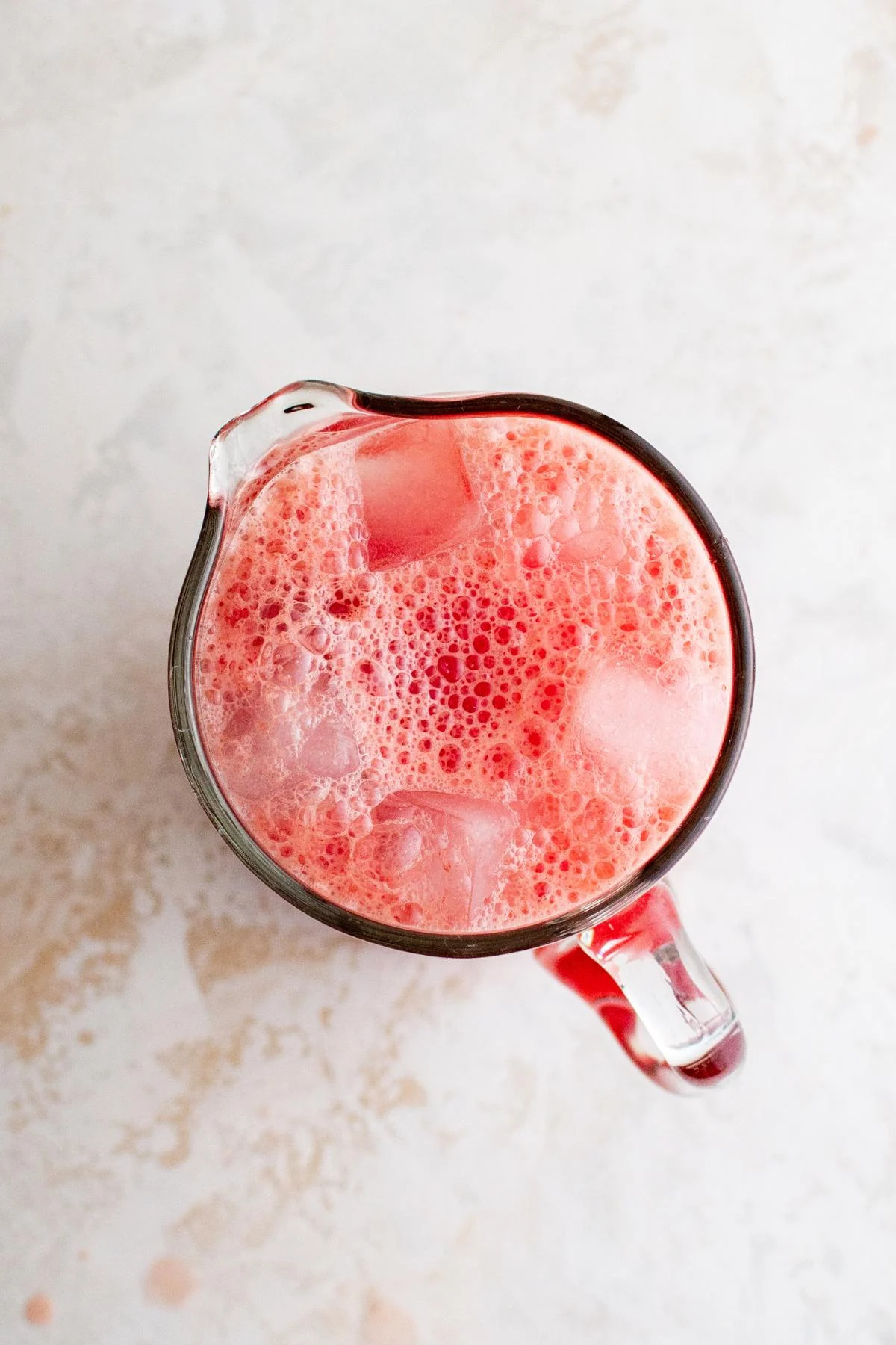 Watermelon agua fresca poured over ice in a pitcher.