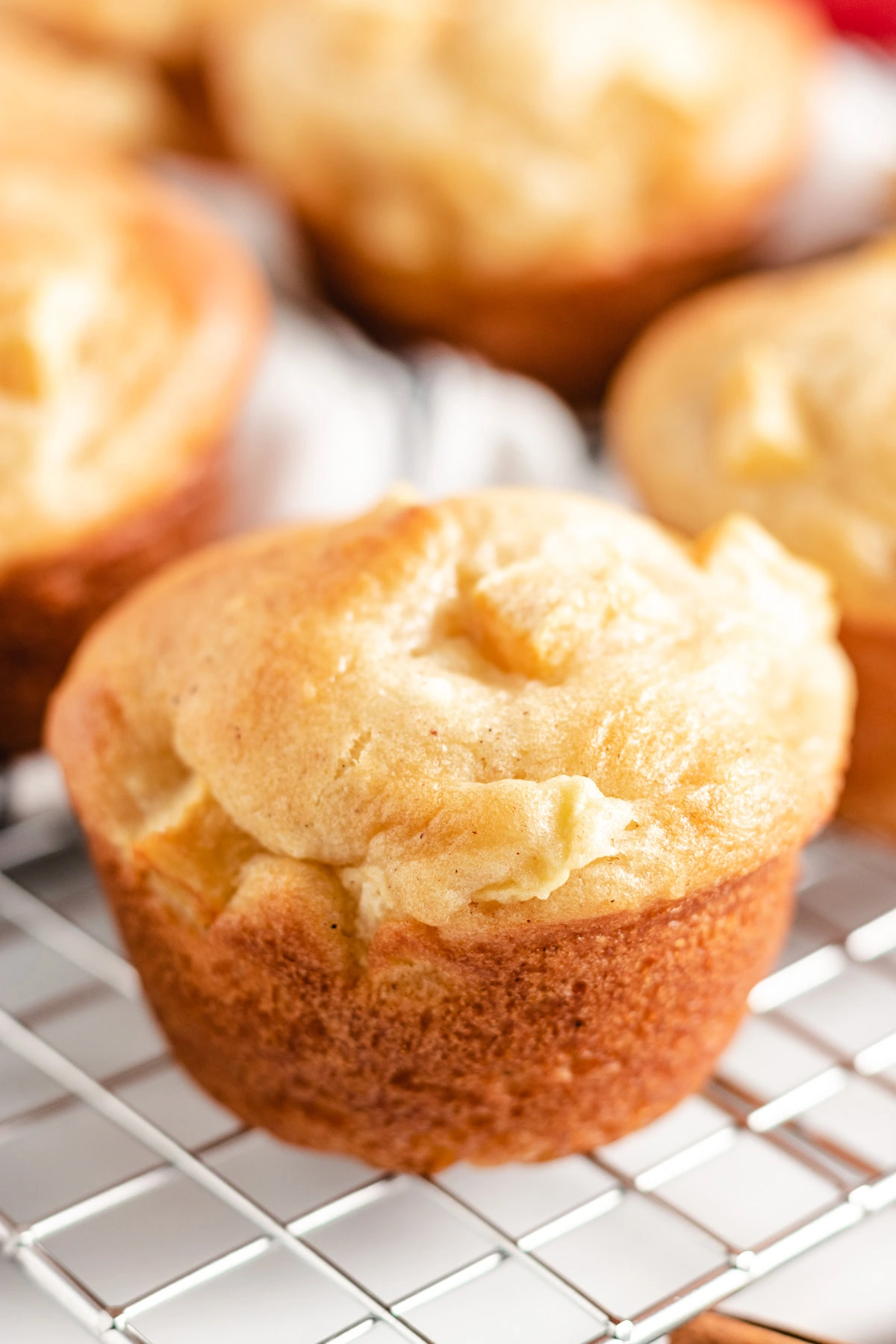 Close up view of gluten free apple cinnamon muffins next to cinnamon sticks.