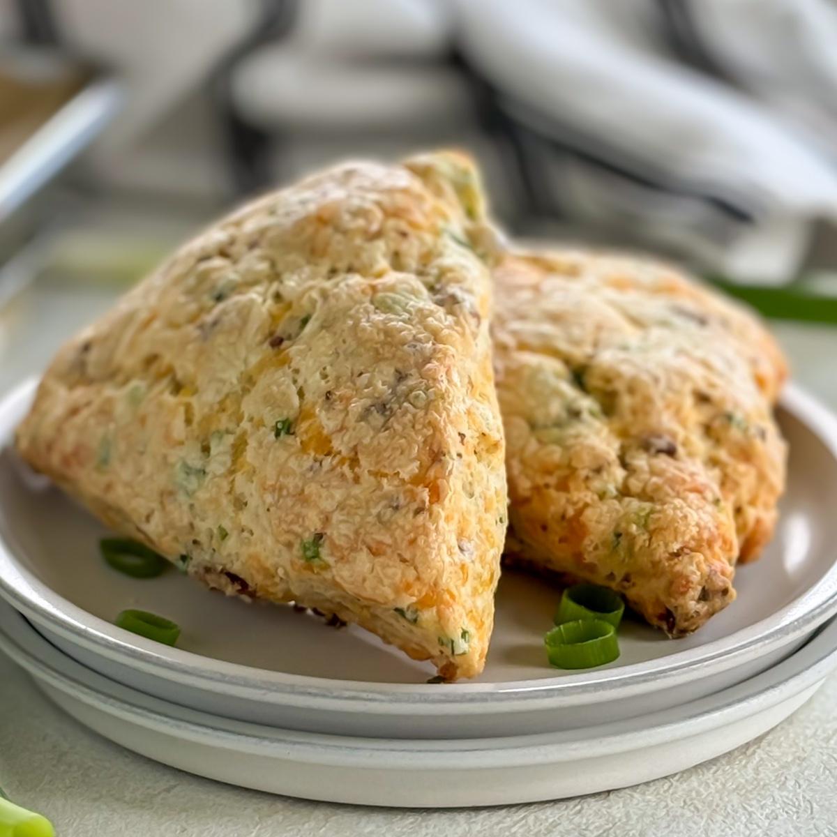 Close up view of bacon cheddar scones on a stack of plates.