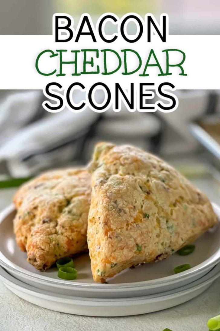 Two bacon cheddar scones leaned against each other on a plate.