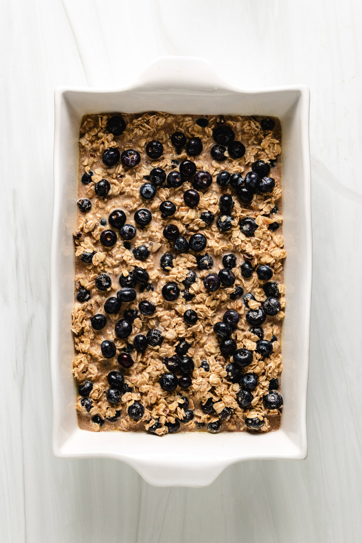 Blueberry oatmeal mixture poured into a white baking dish.