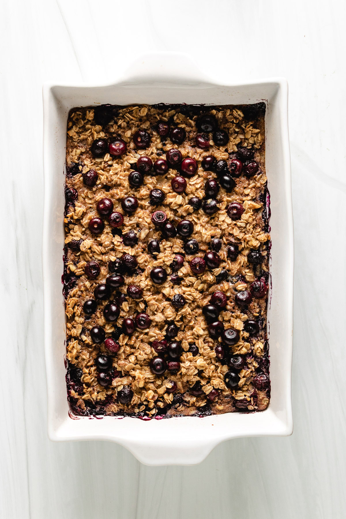Freshly baked oatmeal in a white baking pan.