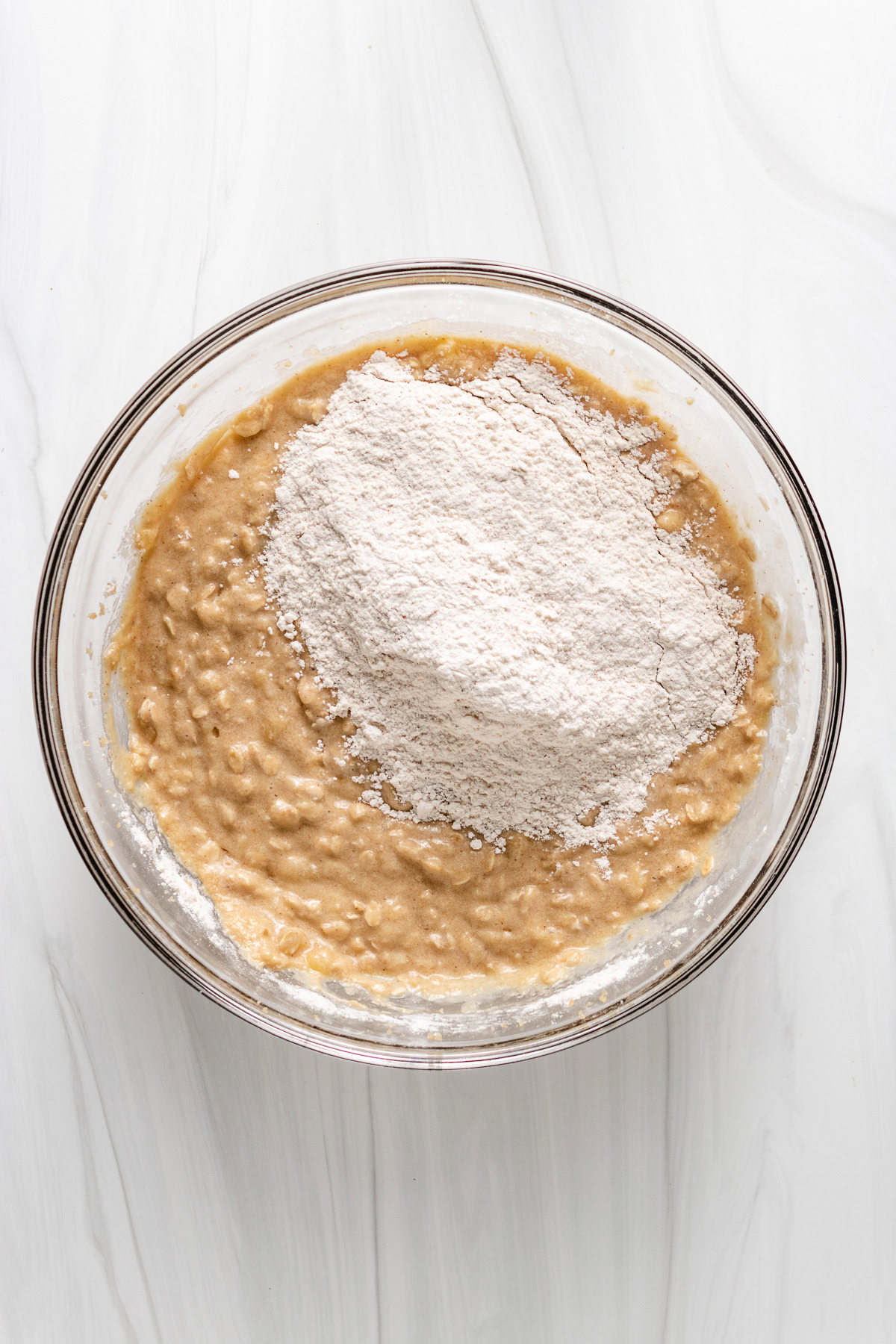 Seasoned flour being added to banana muffin batter.