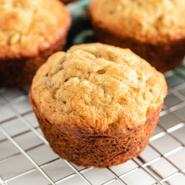 Close up view of a banana oat muffin on a wire rack.