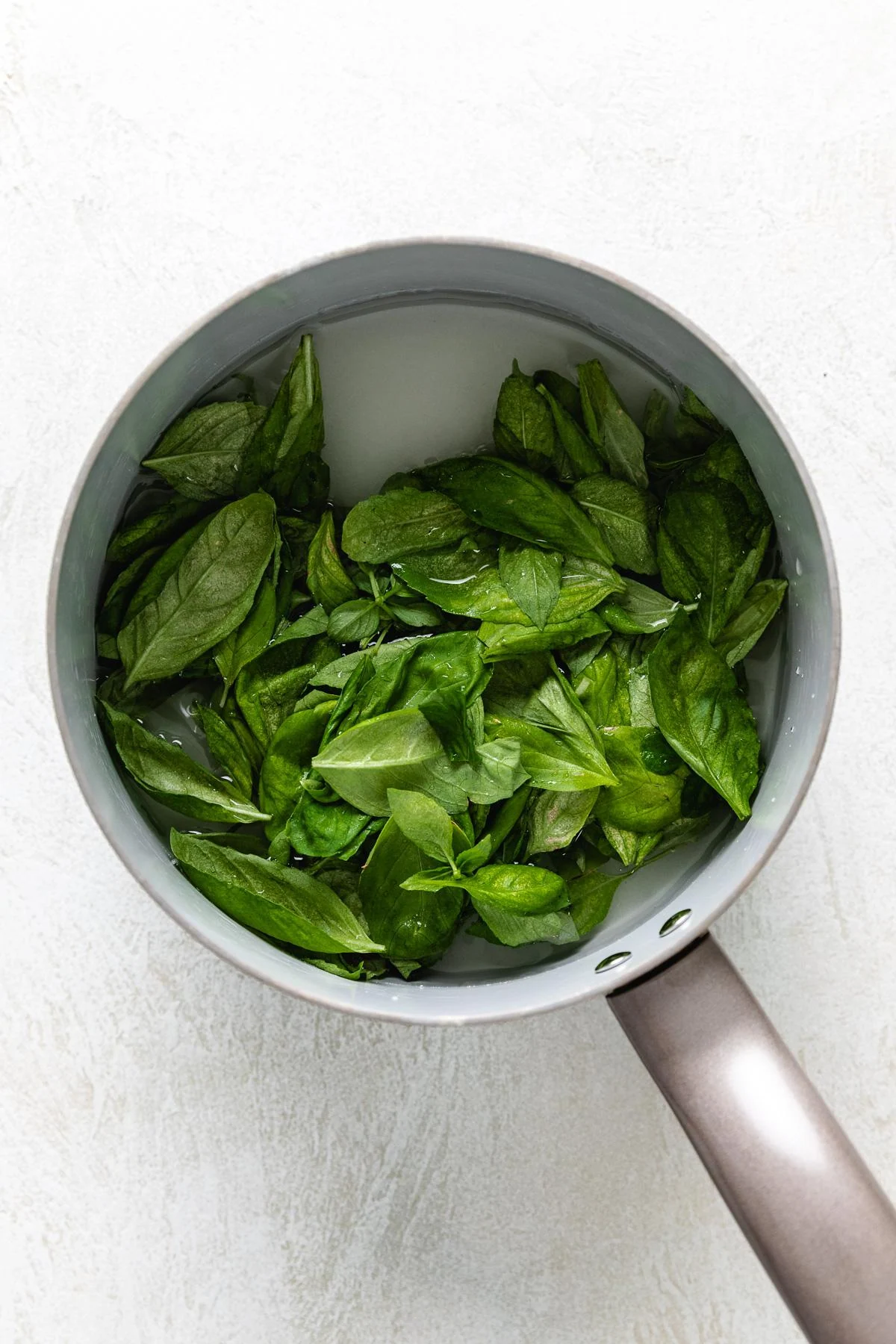 Basil, sugar, and water in a sauce pan.