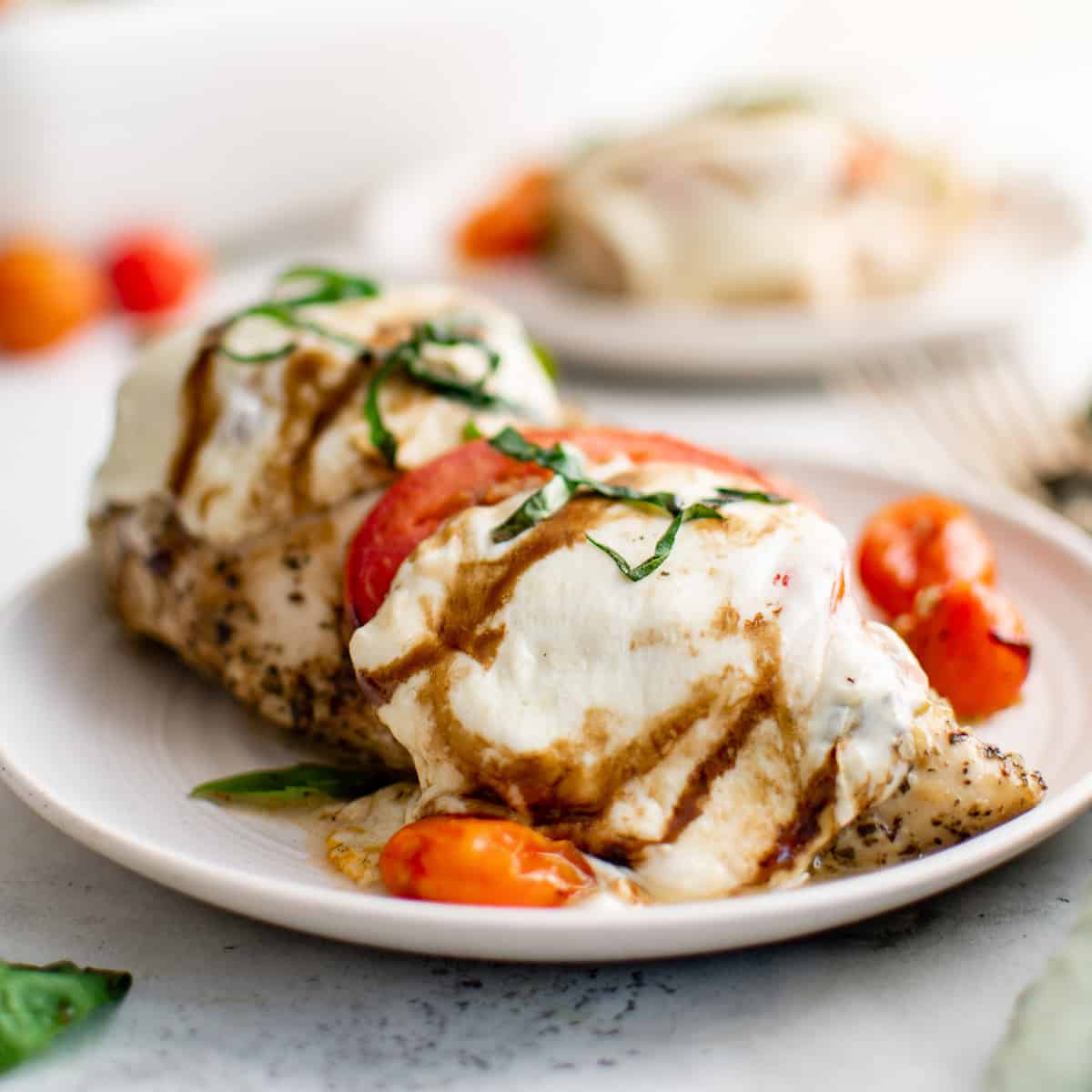 Cheesy chicken caprese on a plate.