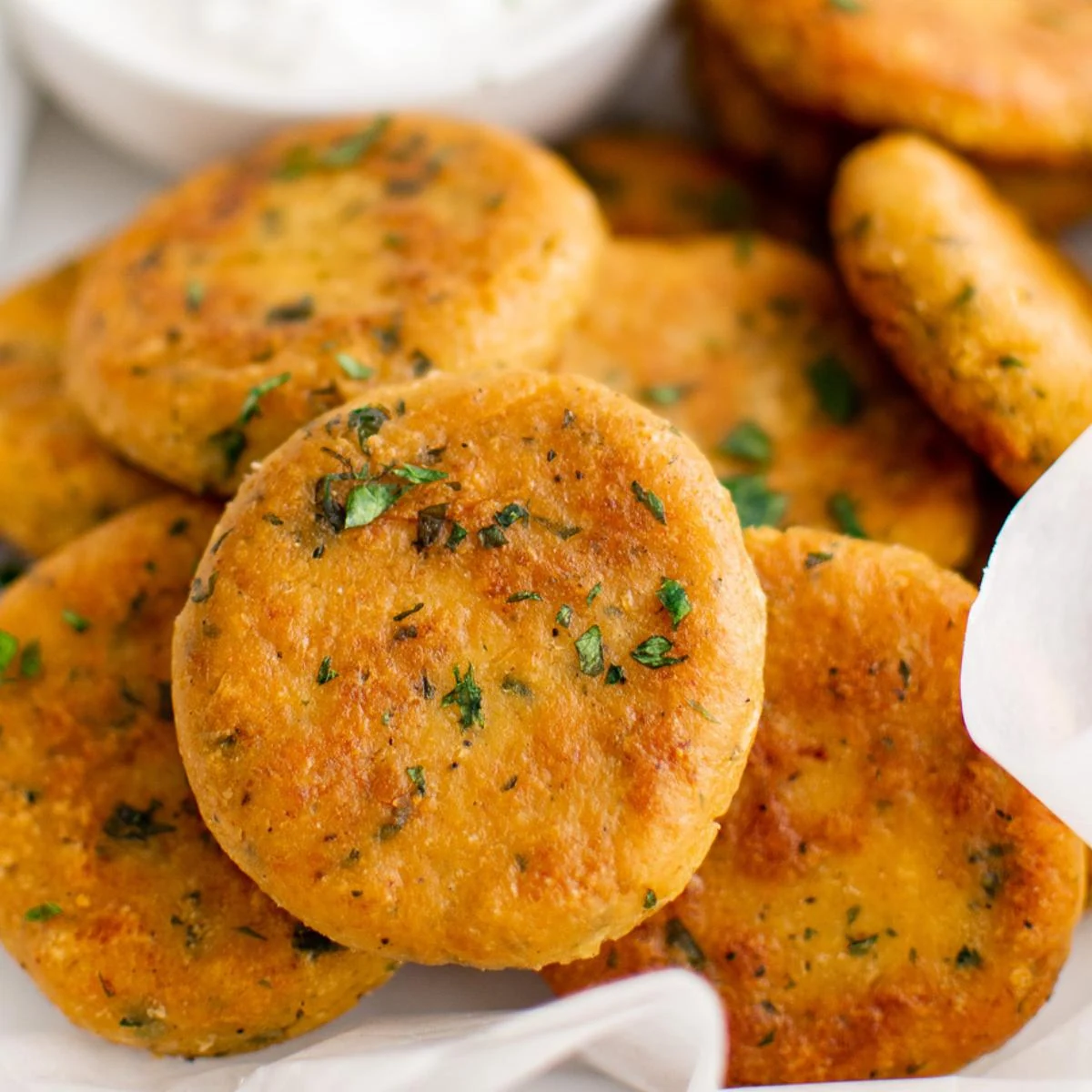 Close up view of chickpea fritters on parchment.