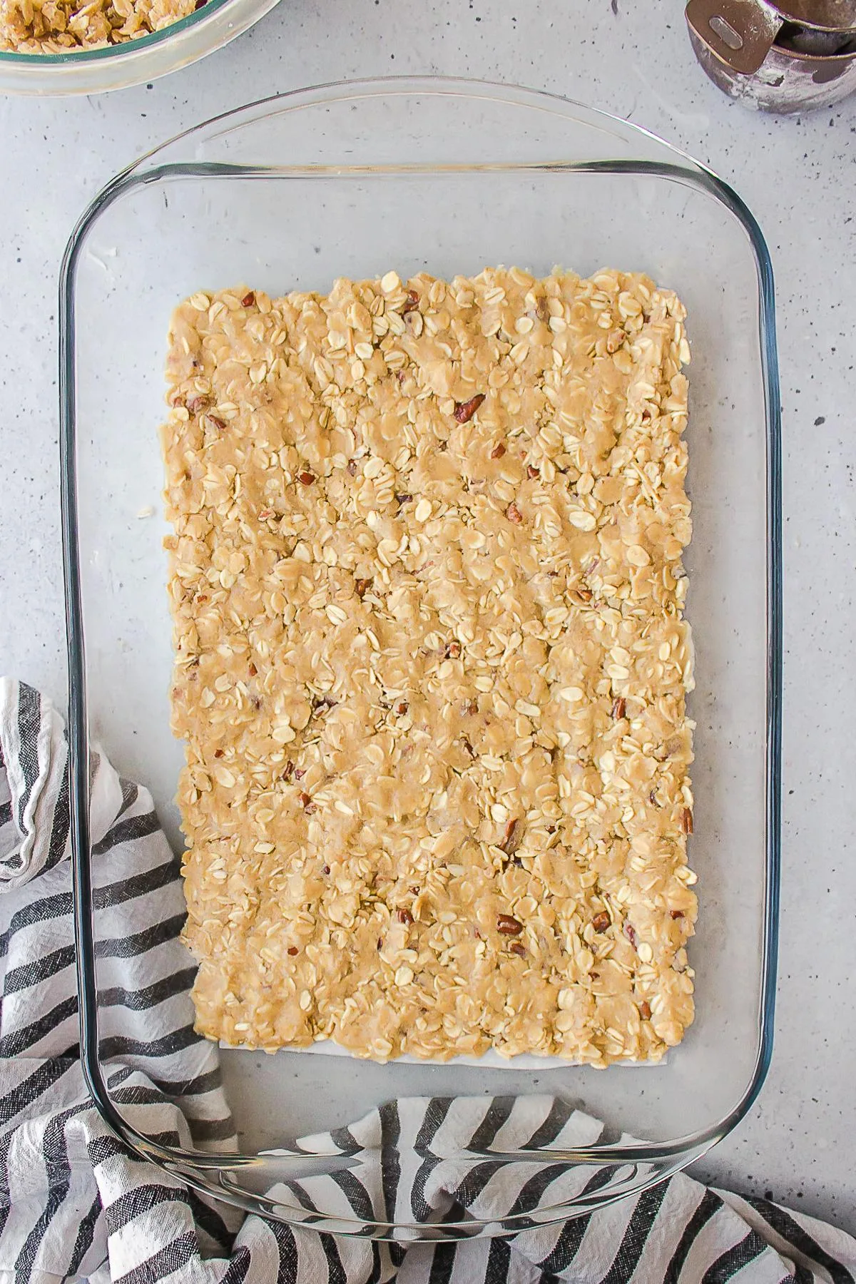 Unbaked oatmeal crumble pressed into the bottom of a dish.