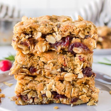 Close-up of homemade oatmeal cranberry bars stacked on a plate.