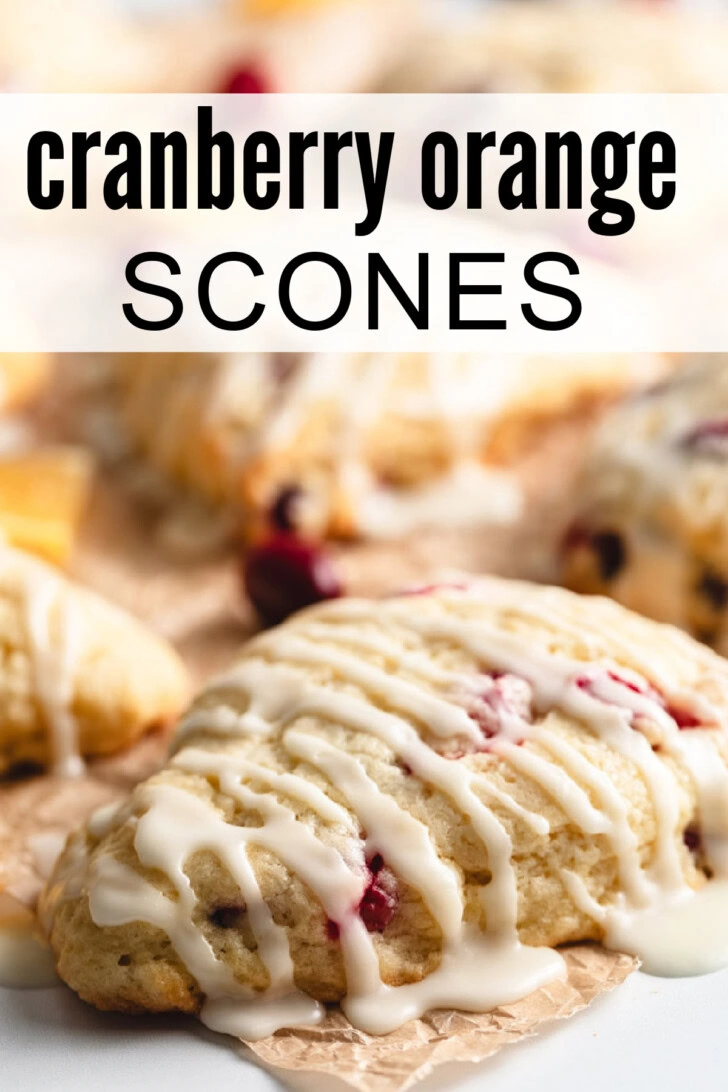 Cranberry orange scones being drizzled with sweet orange glaze.