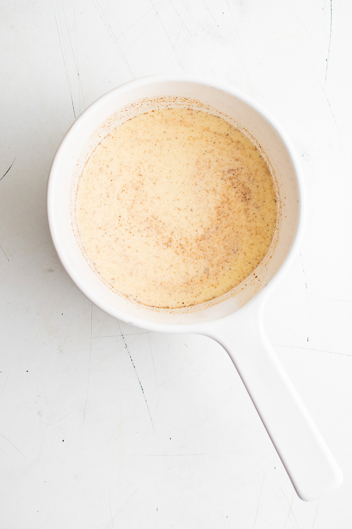Top down view of eggnog milk mixture in a pan.