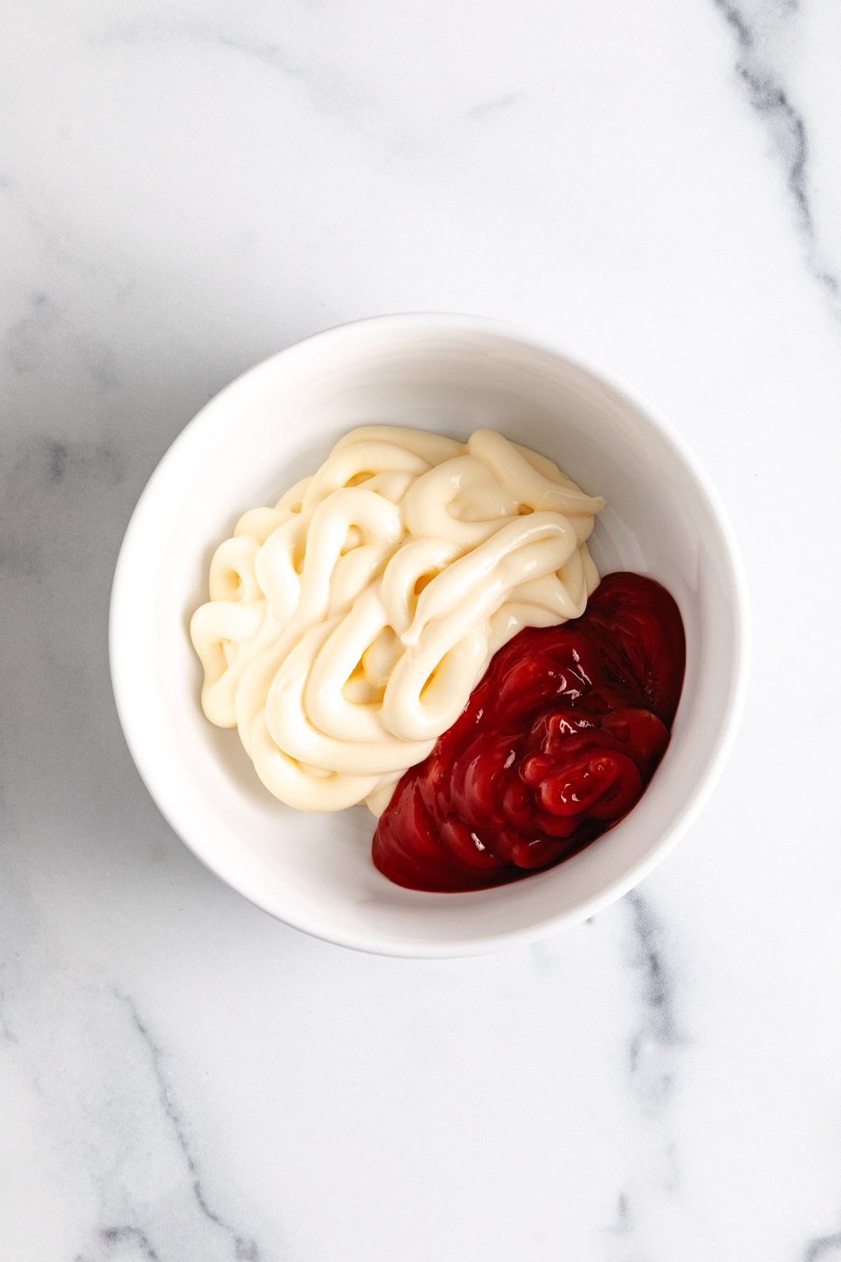 Mayo and ketchup in a white bowl.